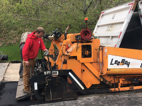 man on paving machine paving a driveway