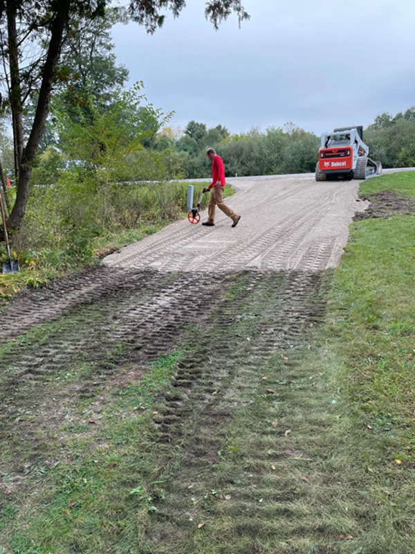 Worker marking driveway with roller